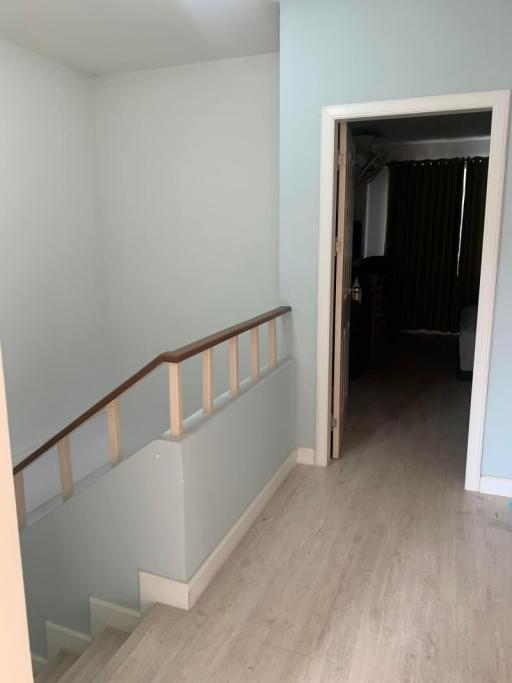 Spacious hallway with wooden flooring leading to the rooms