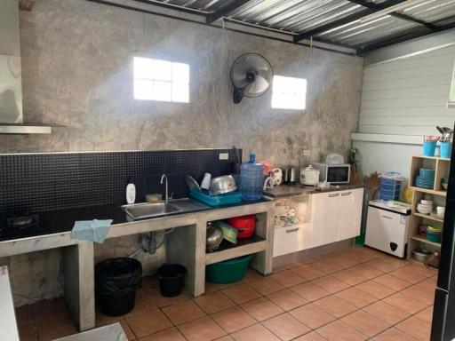 Compact kitchen with concrete countertops and black tile backsplash