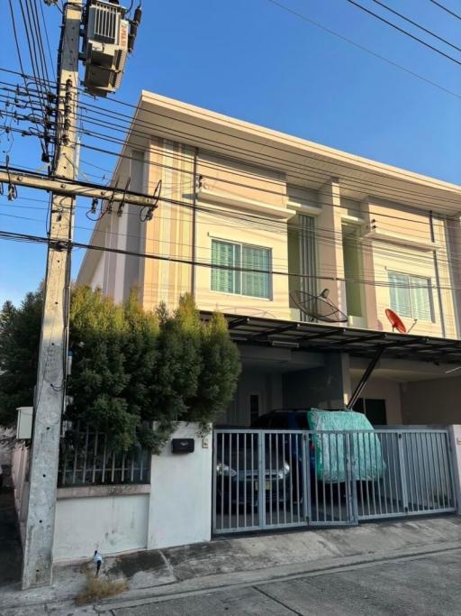 Modern two-story residential building with gated entrance and parking space