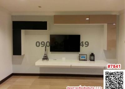 Modern living room with mounted television and white shelving units