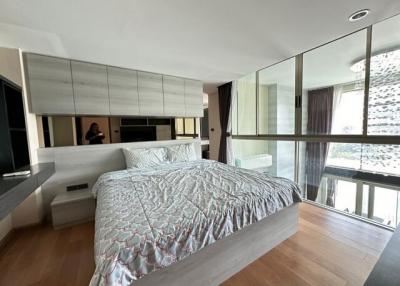 Modern bedroom with floor-to-ceiling windows and hardwood floors