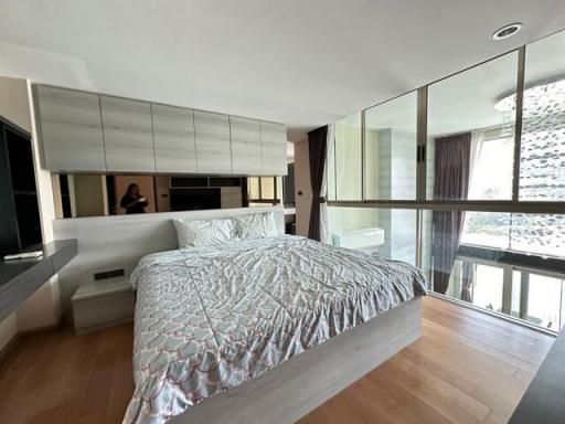Modern bedroom with floor-to-ceiling windows and hardwood floors