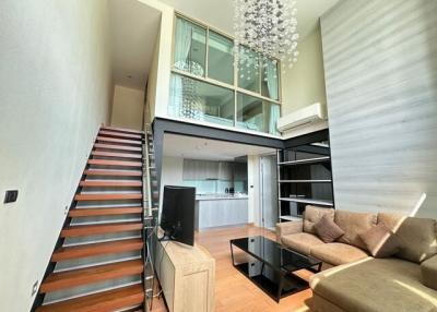 Modern open concept living space with staircase and kitchen view