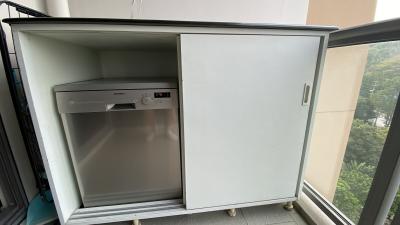 Microwave oven inside a white cabinet on a balcony with a view of trees