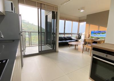 Spacious living room with open kitchen and balcony access
