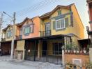 Yellow two-story residential building with balcony and garage