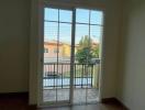 Bright bedroom with hardwood floors and balcony access