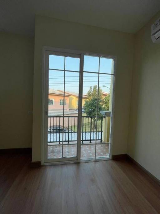 Bright bedroom with hardwood floors and balcony access