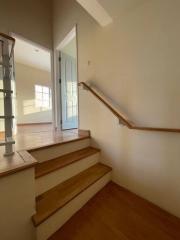 Bright stairway with wood finishes leading to a door