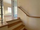 Bright stairway with wood finishes leading to a door