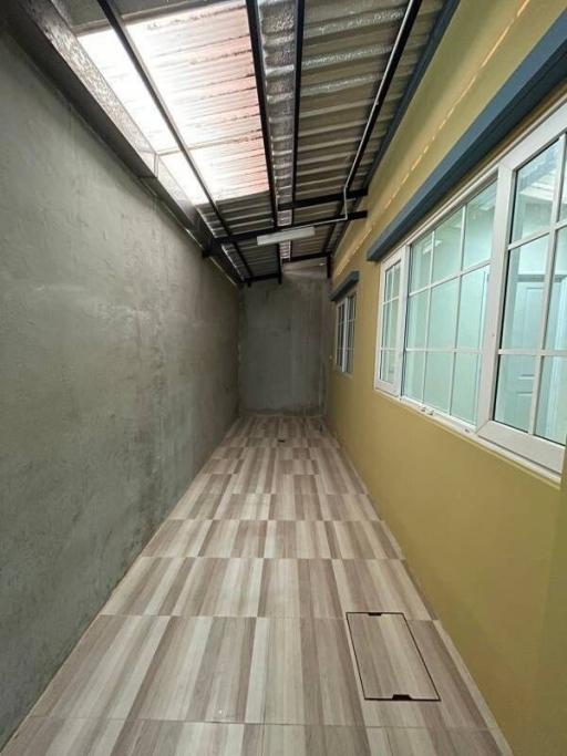 Narrow hallway with tiled flooring and windows