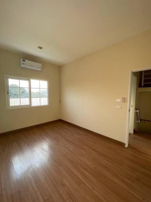 Spacious bedroom with natural light and wooden flooring