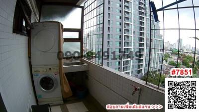Compact laundry room with washing machine in an apartment with city skyline view