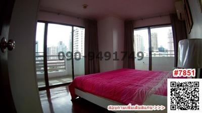 Bright bedroom with city view through large windows