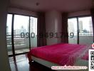 Bright bedroom with city view through large windows