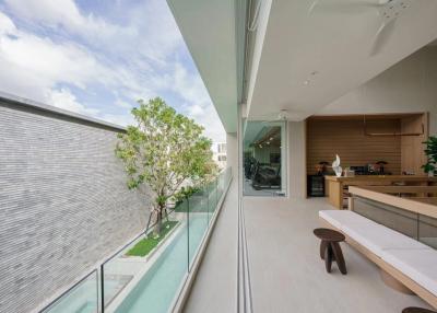 Spacious balcony with glass balustrade overlooking a garden