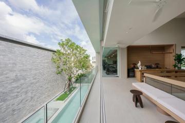 Spacious balcony with glass balustrade overlooking a garden