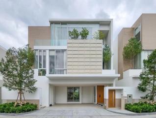 Modern two-story house with a white facade, large windows, and an attached garage