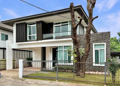 Modern two-story residential home with balcony and garden