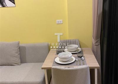 Compact modern living room with bright yellow wall and dining set