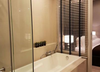 Modern bathroom with glass shower and adjacent bedroom view