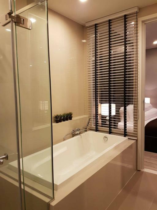 Modern bathroom with glass shower and adjacent bedroom view