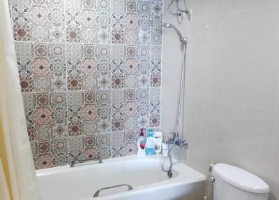 Modern bathroom with tiled walls and bathtub