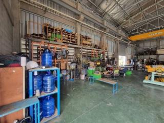 Spacious industrial warehouse interior with various machinery and equipment