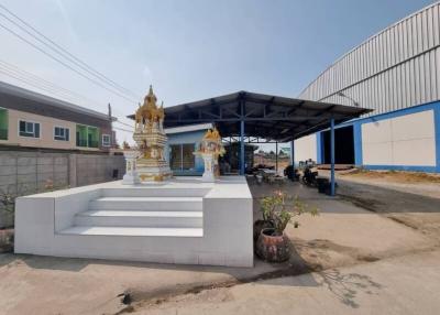 Exterior view of a property with a spirit house and an open garage