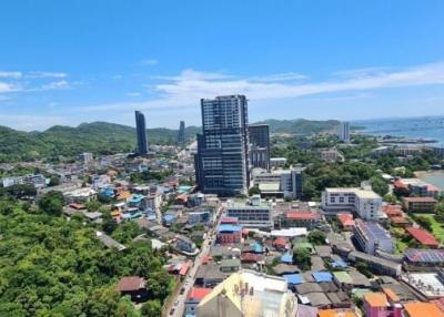 Aerial view of a cityscape with buildings and greenery under a clear blue sky