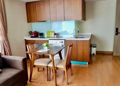 Compact kitchen with wooden cabinets and dining area