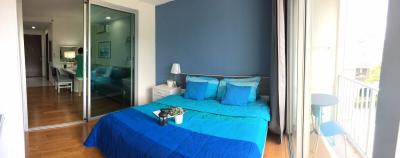 Modern bedroom with blue bedding and balcony access