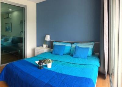Modern bedroom with blue bedding and balcony access