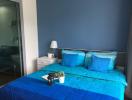 Cozy bedroom with blue bedding and bright interior