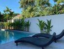 Elegant outdoor pool area with loungers and tropical plants