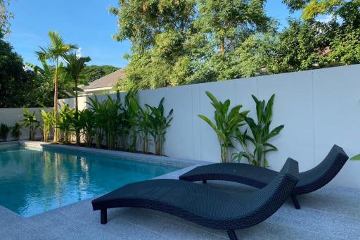 Elegant outdoor pool area with loungers and tropical plants