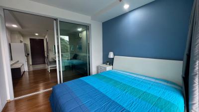 Spacious bedroom with blue bedding and hardwood floors