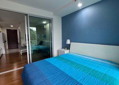 Spacious bedroom with blue bedding and hardwood floors