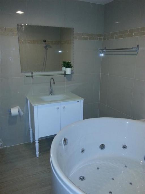 Modern bathroom with whirlpool tub and ceramic tiled walls