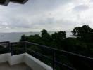 Balcony with scenic ocean view and surrounding greenery