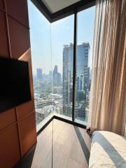 Modern bedroom with floor-to-ceiling windows and city view