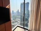 Modern bedroom with floor-to-ceiling windows and city view