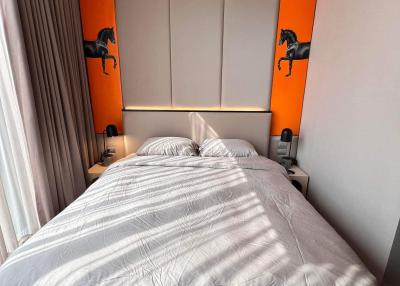 Contemporary bedroom with a large bed and orange accents