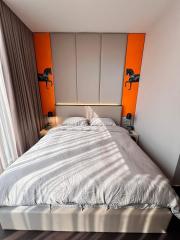 Contemporary bedroom with a large bed and orange accents