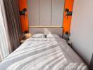 Contemporary bedroom with a large bed and orange accents