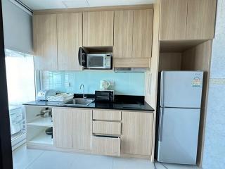 Modern compact kitchen with wooden cabinets and integrated appliances