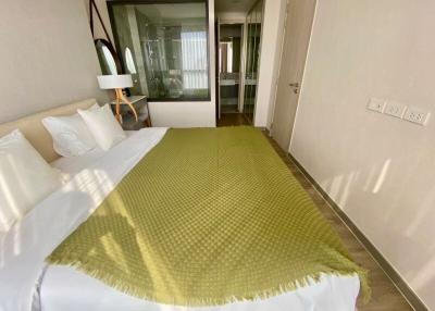 Cozy bedroom with a green bedspread and balcony access
