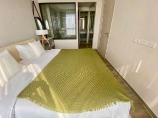 Cozy bedroom with a green bedspread and balcony access