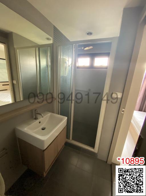 Compact bathroom interior with a shower cabin and a single sink vanity