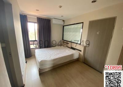 Modern bedroom interior with a comfortable double bed, window with curtains, air conditioning unit, and wooden flooring